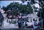 Fruit Vendors and Patrons Gathered Across from a Stone Church in Antigua
