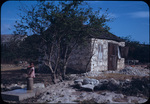 A young girl stands near a stone building in Rock Sound, Eleuthera, Bahamas