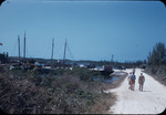 Three men walk towards docked boats near Hatchet Bay, Eleuthera, Bahamas.