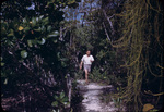 A man walks along a sandy path near Nicholls Town, Andros, Bahamas
