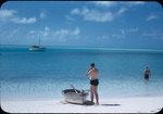 Two men and a row boat on a beach in the Exumas, Bahamas