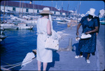 A woman with conch meat passes by another woman near Nassau Harbor, New Providence, Bahamas