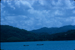 Jamaican fishermen in canoes with the mountains in the distance