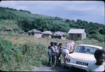Children, tourists, and huts near the coast in Northern Saint Vincent