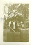 Photograph of man with pipe and garden tool.