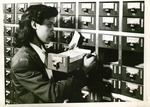 Female student uses libary card catalog