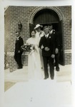 Bridal party exits brick church after first wedding, July 9, 1939