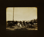 Children Standing with Men Sitting on Horses in Field