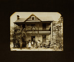 Man and Children Standing in Front of House