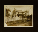 Man and Woman Standing Next to House