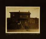 Men, Women, and a Dog Standing in Front of House