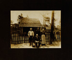 One Woman and Three Men Posing in Front of House