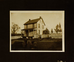 Parents and Four Children Standing in Front of House
