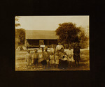 Parents and Nine Children Posing in Front of House