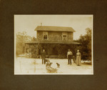Two Men and One Woman Standing in Front of House with Dogs
