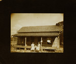 Two Women and Baby Sitting on Steps of House