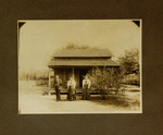 Two Women and One Man Posing in Front of House
