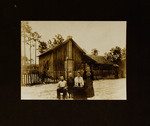 Two Women, One Man, and One Child Posing in Front of House