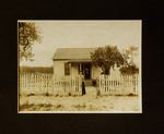 Woman Leaning on Fence in Front of House