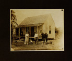 Woman, Man, Baby and Horse Standing in Front of House