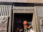 Detail of Door with Flowers and Carved Name Above Door. Facade of Duarte Family Mausoleum, With Plaques. Recoleta Cemetery