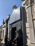 Facade of Duarte Family Mausoleum, With Plaques and Flowers and a View of Neighboring Mausoleums and Tombs. Recoleta Cemetery 1 by Wendy Howard