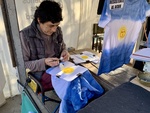 Artist Making Tie-Dye T-Shirts with Sun Design in Outdoor Market. Recoleta Area. 1 by Wendy Howard