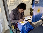 Artist Making Tie-Dye T-Shirts with Sun Design in Outdoor Market. Recoleta Area. 2 by Wendy Howard