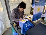 Artist Making Tie-Dye T-Shirts with Sun Design in Outdoor Market. Recoleta Area. 3 by Wendy Howard