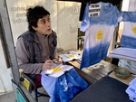 Artist Making Tie-Dye T-Shirts with Sun Design in Outdoor Market. Recoleta Area. 4 by Wendy Howard