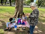 Children studying under a tree while an adult observes in Parque Los Andes in Buenos Aires, Argentina by Wendy Howard