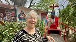 Woman interacts with Gauchito Gil tribute at Santuario del Gauchito Gil in Parque Los Andes, Argentina by Wendy Howard