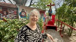 Visitor interacts with statue at Santuario del Gauchito Gil in Parque Los Andes, Argentina on a sunny day by Wendy Howard
