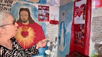Woman interacting with religious art and community messages at Santuario del Gauchito Gil in Parque Los Andes, Argentina by Wendy Howard