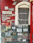 Wall of plaques at Santuario del Gauchito Gil in Parque Los Andes in Argentina showing gratitude and remembrance from visitors by Wendy Howard