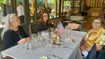 Three women seated at a table in Lamadrid Estate Wines during a gathering in Mendoza Argentina enjoying food and conversation by Wendy Howard