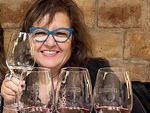 Woman enjoying a wine tasting at Bodega Familia Cassone in Mendoza, Argentina with glasses in front of her by Wendy Howard