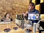 Wine tasting event at Bodega Familia Cassone winery in Mendoza, Argentina with participants engaged in discussion by Wendy Howard