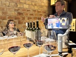 Visitors engage in a wine tasting session at Bodega Familia Cassone winery in Mendoza, Argentina, discussing wine and tasting techniques by Wendy Howard