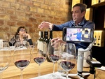 Wine tasting experience at Bodega Familia Cassone in Mendoza, Argentina, featuring a guide explaining wine details to guests by Wendy Howard