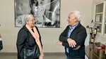 Visitors enjoy conversation at Bodega Carmelo Patti winery in Mendoza, Argentina with a backdrop of the owner‚Äôs portrait by Wendy Howard