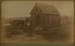 Men Standing in Front of Shack and Barn