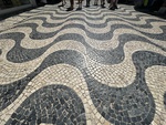 Wavy cobblestone streets of Lisbon with people walking in the background by Wendy Howard