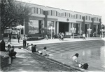 Millican Hall, students sit by the Reflecting Pond